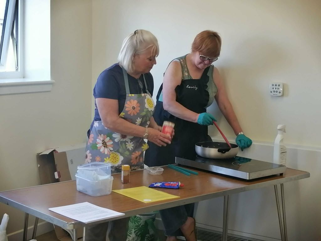 Two volunteers give a cookery demonstration